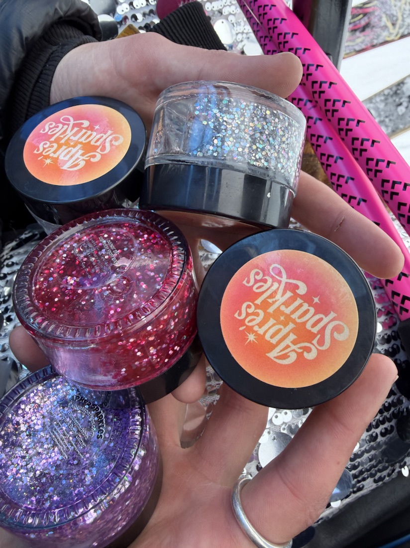 A handful of Après Sparkles glitter jars with branded lids