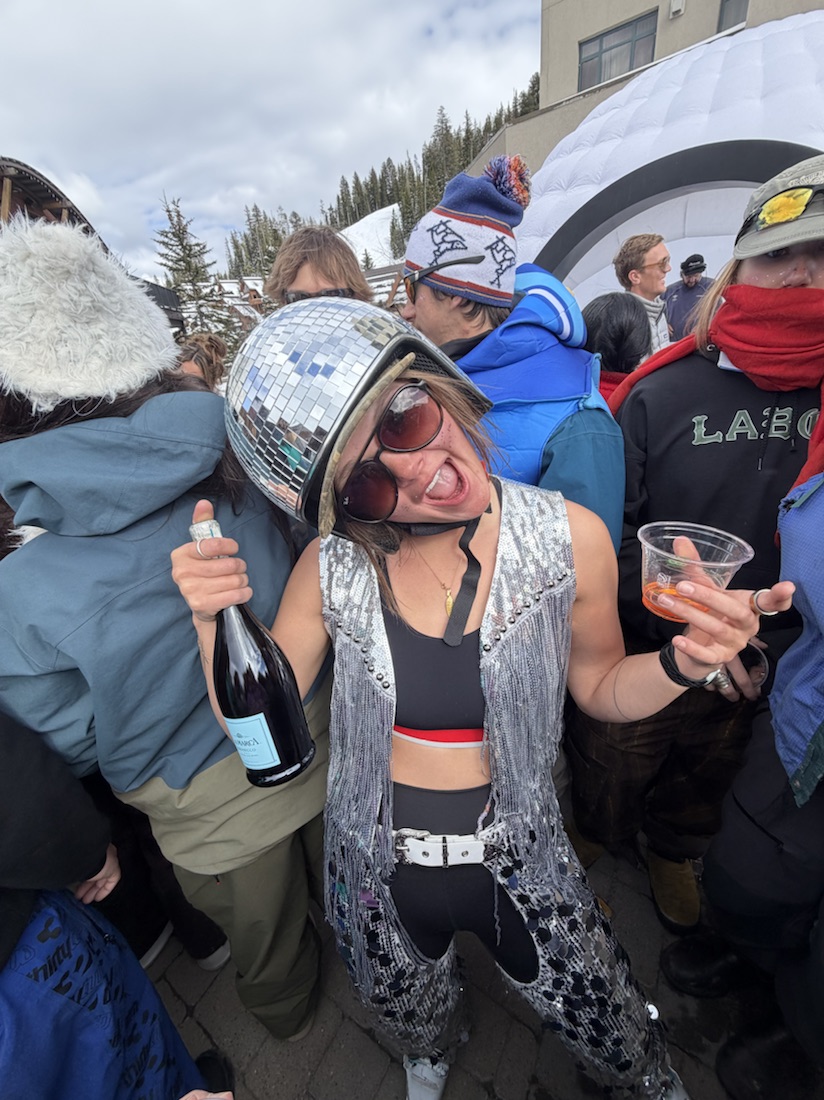 Friends celebrating après-ski in disco-ball helmets and sparkles